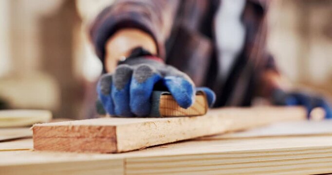 Hands, carpenter and sanding in workshop with wood, smooth surface and manufacturing process. Person, sandpaper and timber for carpentry, lumber restoration and prepare finish of furniture production