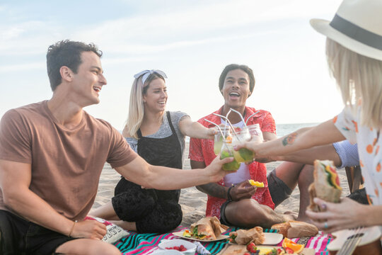 Friends enjoying beach picnic together.