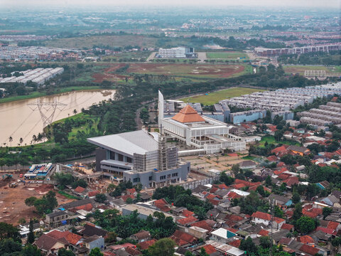 Aerial view of Masjid Raya BSD Baitul Mukhtar surrounded by urban rooftops, a lake, and green spaces in Kecamatan Pagedangan, Banten, Indonesia.