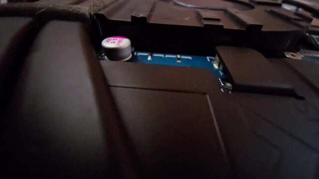Macro close-up of a laptop internal motherboard component showing a surface-mount electrolytic capacitor during repair