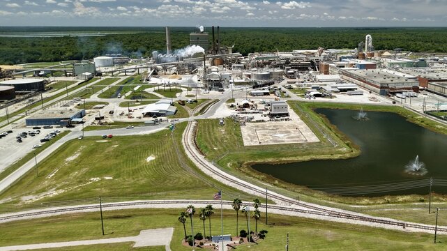 Aerial view of Georgia-Pacific Palatka Operations, an industrial paper mill with smoking chimneys, storage tanks, railway tracks, and a pond in Palatka, Florida, United States.