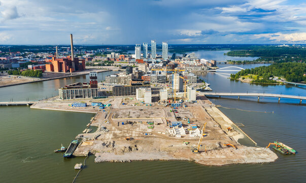 Aerial view of the Kalasatama district featuring modern high-rise buildings, ongoing construction sites, and waterfront infrastructure in Helsinki, Uusimaa, Finland.