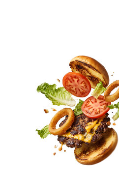 Cheeseburger Bursting Apart with Melting Cheese, Grilled Beef Patty, Onion Rings, Lettuce and Tomato Falling in Air on Transparent Background