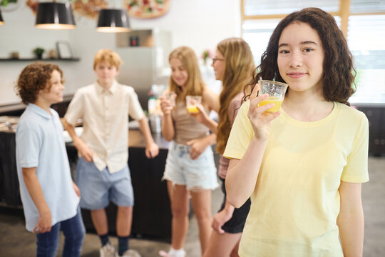 Group of teenagers enjoying a juice break in a modern school cafeteria