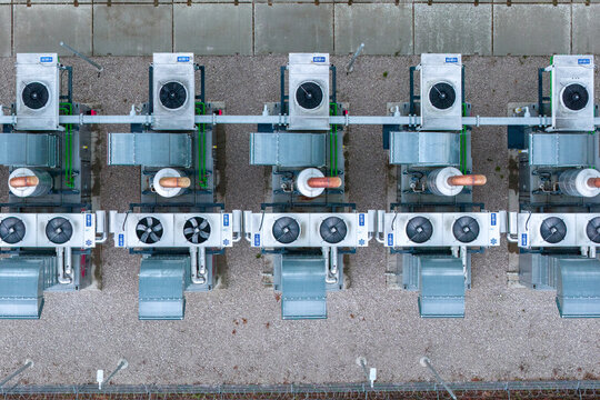 Aerial view of industrial HVAC cooling units arranged in a row on a gravel surface in Nasedlovice, South Moravian Region, Czechia.