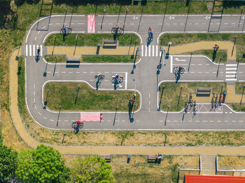 Aerial view of a traffic education park with children cycling on paths with road markings, crosswalks, and benches in Kyjov, South Moravian Region, Czechia.