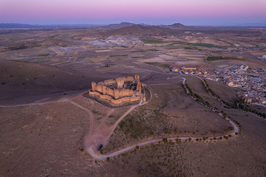 Aerial view of the historic ruins of Castle Almonacid of Toledo situated on a hilltop overlooking the surrounding landscape at sunset in Almonacid de Toledo, Castilla-La Mancha, Spain.