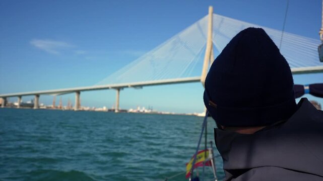 Sailor navigating under the constitution bridge of 1812 in cadiz