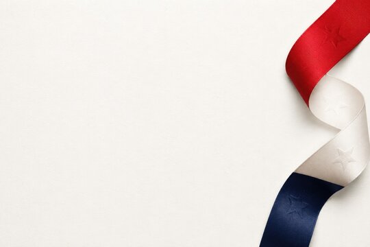 Flowing red, white, blue ribbon elegantly twists on smooth surface, evoking harmony.