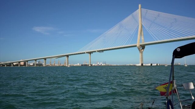 Sailing boat navigating under the constitution bridge in cadiz