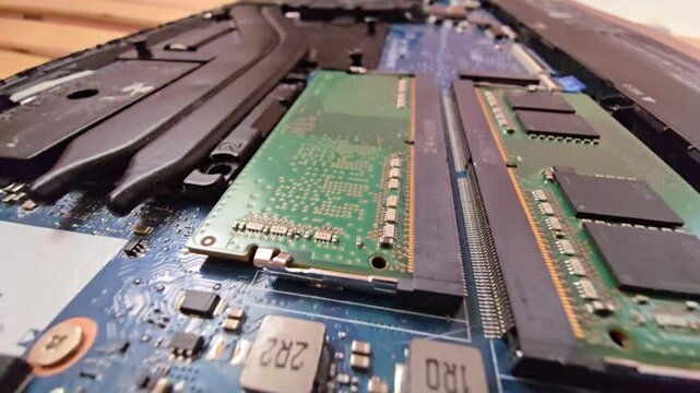 Macro close-up shot of a laptop motherboard, showcasing installed RAM memory sticks and slots on the circuit board.