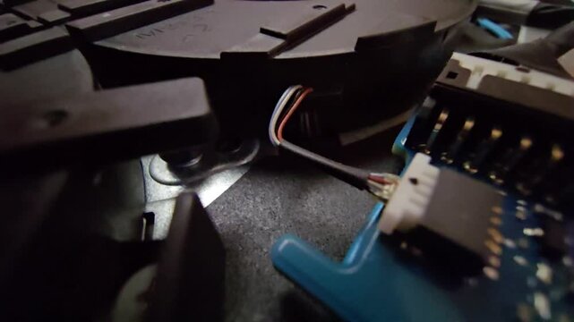 Macro close-up shot of a laptop circuit board, showcasing internal wire connectors and speaker plug sockets with intricate electronic components.