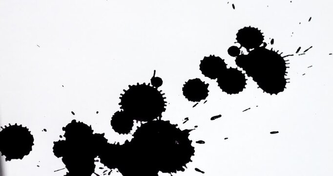 Ink splashes on a white sheet of paper. Black paint stains on a white background.