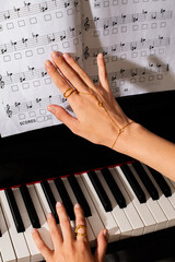 pianist female hands wearing jewelry playing piano and music notes  © Елизавета Фильченко
