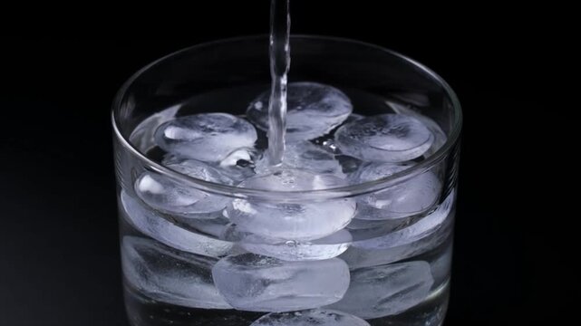Sparkling ice water background clear glass close view texture refreshment liquid purity chill transparent cube closeup dark backdrop minimal style calm splash detail pouring cool drink freshness cold