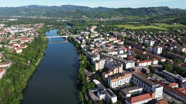 Aerial drone panorama of modern Maribor featuring the Drava River, Mariborski Otok, residential neighborhoods, a river bridge and Kamnica in the distance, Slovenia.