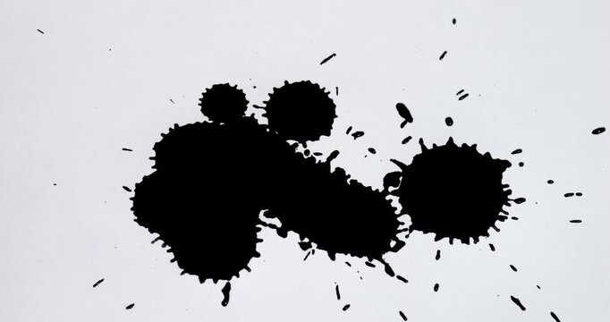 Ink splashes on a white sheet of paper. Black paint stains on a white background.