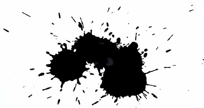 Ink splashes on a white sheet of paper. Black paint stains on a white background.
