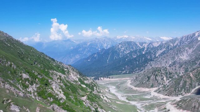Wide mountain valley with distant forest and snowcapped peaks between Kalam and Thal, Upper Dir, Khyber Pakhtunkhwa, Pakistan