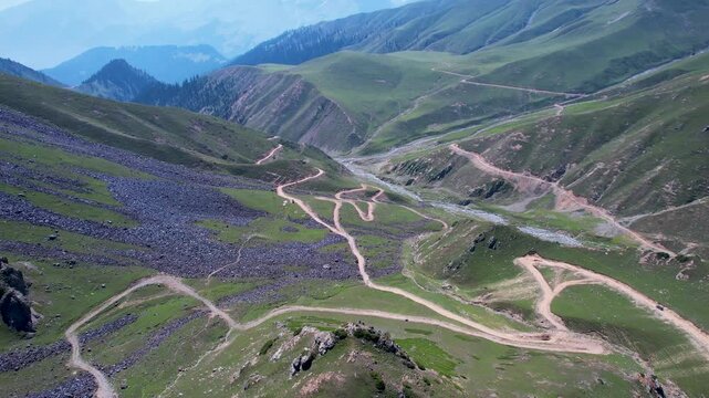 Winding mountain roads cross green valleys below Badgoi Pass in the Hindu Kush, Upper Dir, Khyber Pakhtunkhwa, Pakistan