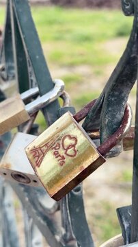 Love padlock with Eiffel Tower engraving hanging on bridge in Paris, France