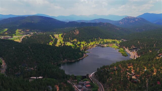 Aerial drone view of downtown Downtown Evergreen Colorado foothill Evergreen Lake Golf Course Mount Blue sky Front Range Rocky Mountain small town summer spring sunny cloudy morning blue sky backwards