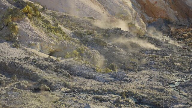 Rising steam from geothermal vents and fumaroles surrounded by sulfur deposits and volcanic rocks in the geologically active Jigokudani Hell Valley, located in Noboribetsu, Hokkaido