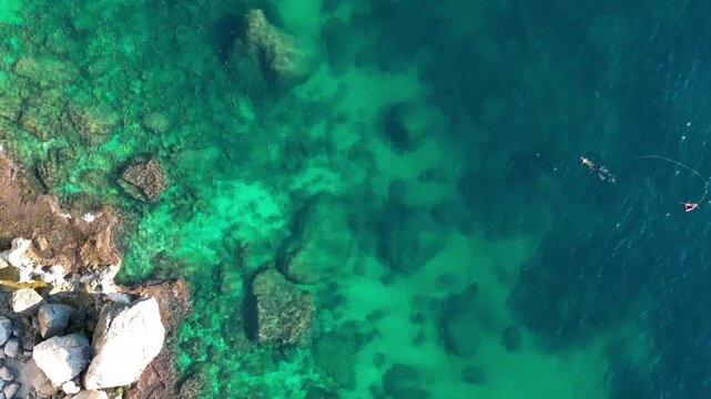 Aerial view of the rocky coastline meeting the clear turquoise Mediterranean sea in Calp, Valencian Community, Spain.