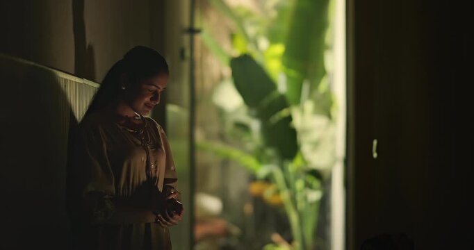 Indian young adult gen z sad stress woman look upset feel bad fail hurt head ache in dark living room. Alone tired female girl think deep suffer low health issue lost job guilt indoor house home place