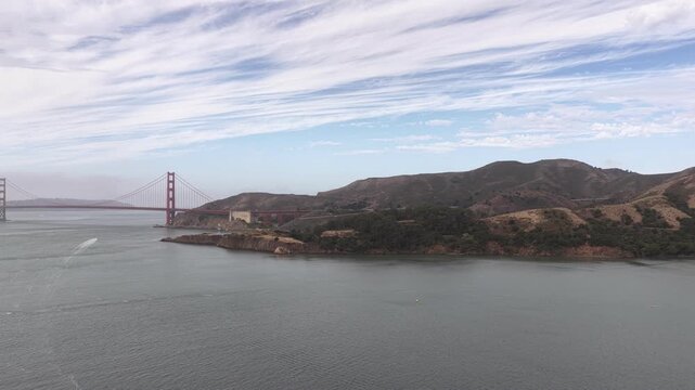 Aerial footage captures the Golden Gate Bridge, Sausalito hills, and San Francisco Bay on a clear day. Tracking drone shot