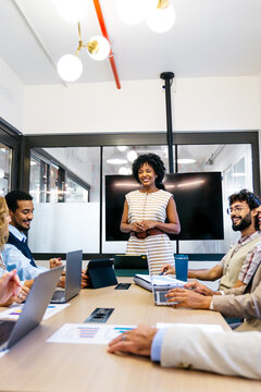 Professional multi ethnic colleagues engaged in a business meeting, discussing graphs and working together on projects