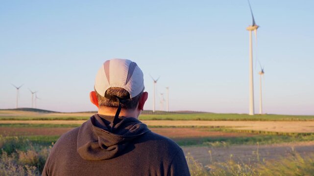Man watching wind turbines generating renewable energy