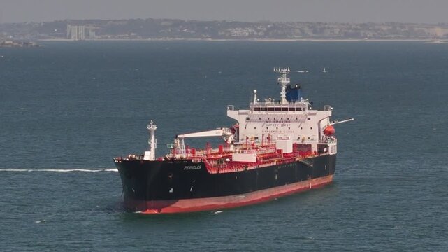 Aerial view of chemical transport vessel Pericles sailing on the water with a small support boat nearby in Lisbon, Lisbon, Portugal.
