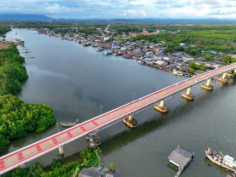Aerial view landscape of fishing community along river, nestled within lush green mangrove forest of Pak Nam Prasae estuary in Rayong, Thailand. Ecotourism and sustainable travel. Net zero tourism.