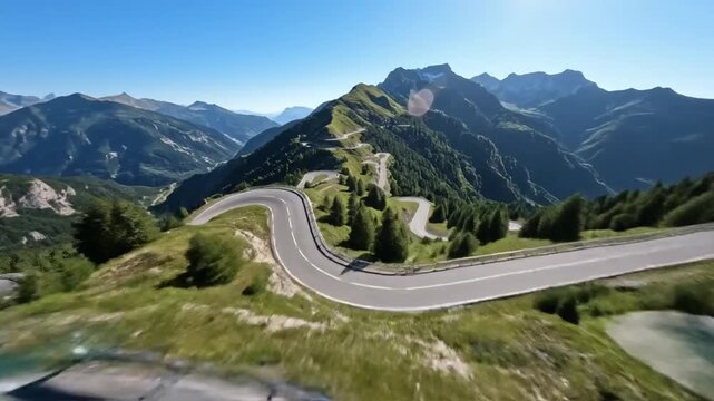 Serpentine Mountain Road: A winding asphalt road snakes through the majestic alpine landscape, surrounded by verdant green mountains and clear blue sky.