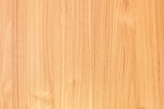 Close-up of light warm-toned wood grain surface with smooth vertical texture and natural knots.