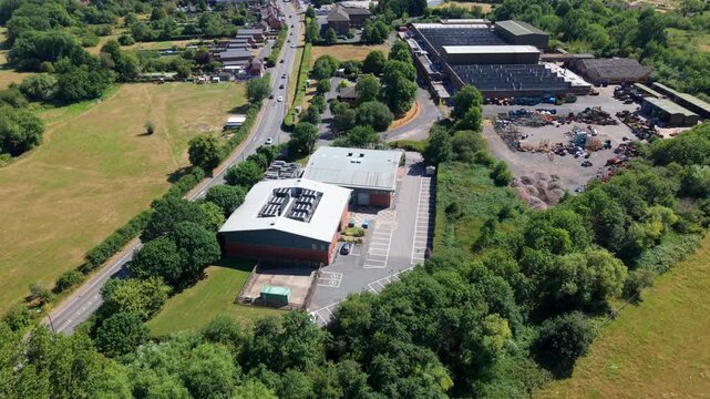 Aerial view of data center cooling fans on a rooftop surrounded by trees and a road in Redditch, England, United Kingdom.