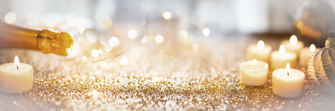 Festive sparkling new years eve background with champage and candle lights.