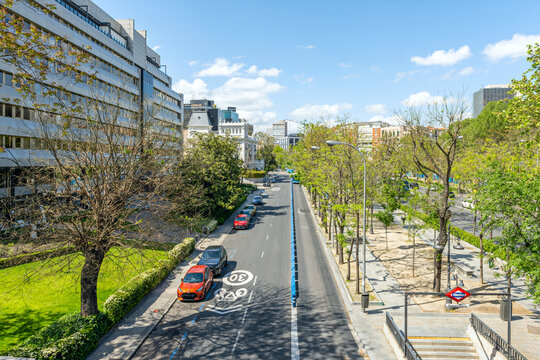 Elevated view of Rub&eacute;n Dar&iacute;o metro entrance beside tree-lined Madrid street with parked cars and 30 speed marking