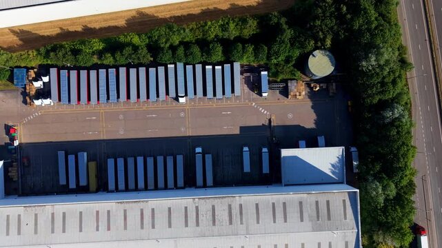 Aerial view of Daventry International Rail Freight Terminal with rows of parked semi-trailers and warehouse facilities in Kilsby, England, United Kingdom.