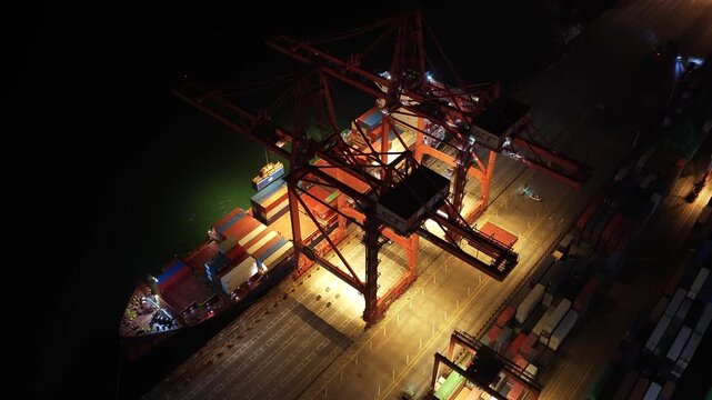 Unloading large cargo containers seaport. Loading freight sea port. Top aerial drone view. Lot big boxes rows, ship delivery ocean harbor. Shipping night. Goods export import. Industrial Marine dock.