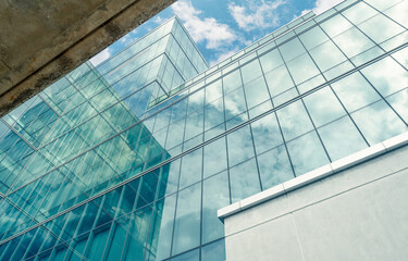 Obraz premium Modern sustainable glass office building with reflective facade. Exterior architecture of corporate headquarters. Energy efficiency, financial business, innovation, ESG, smart city development.