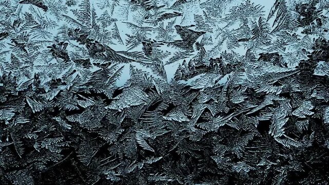 Frost patterns on glass, close-up, abstract ice formations, winter close-up
