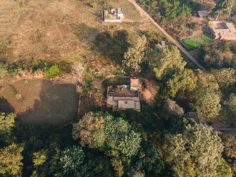 Aerial view of the Daphar Plantation Forest in Punjab, showing rural dwellings, agricultural fields, and dense woodland in Chak No. 27, Punjab, Pakistan.