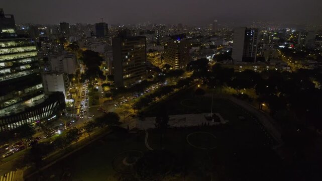 Aerial view of the illuminated streets and modern buildings of Miraflores at night in Miraflores, Lima Province, Peru.