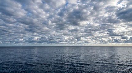 Fototapeta premium Scenic view of dramatic cloudy sky over calm blue ocean water at the horizon line