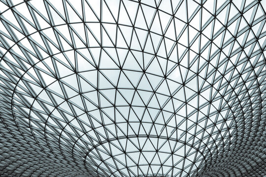 Modern glass and steel geometric dome roof with triangular pattern, futuristic architectural structure, abstract symmetry background for engineering, construction, innovation and technology design.