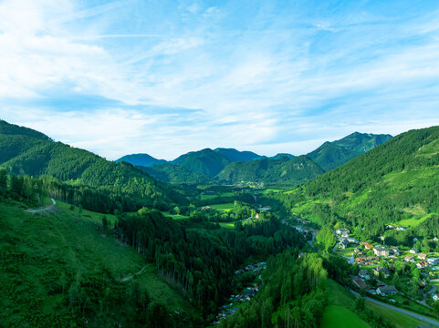 Aerial view of the alps overlooking the town nestled in the lush green valley of Sankt Gallen, Styria, Austria.