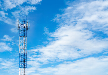 Obraz premium Telecommunication tower with blue sky and white clouds background. Antenna on blue sky. Radio and satellite pole. Communication technology. Telecommunication industry. Mobile or telecom 4g network.