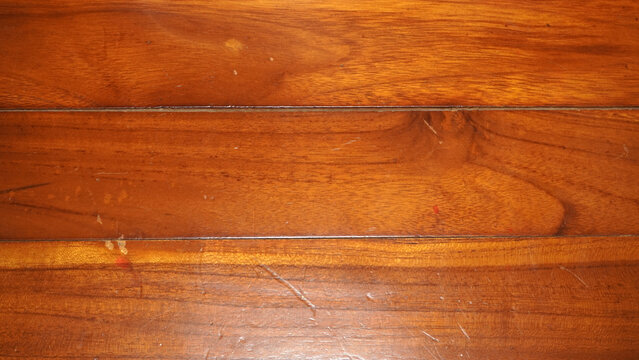 Close-up of polished wooden floor planks with natural grain texture.